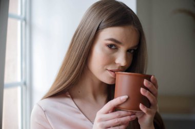 Güzel kız kahve içme ve kafede otururken gülümseyen