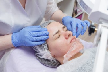 Kız güzellik salonunda bir ultrason cilt temizleme hizmeti ile sağlanır.