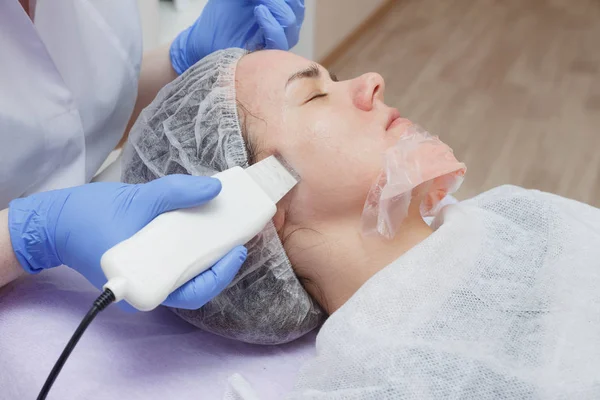 The girl is provided with an ultrasound skin cleaning service in the beauty salon. — Stock Photo, Image