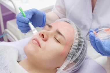 Usta genç bir kızın yüzünde bir maske oluşturur.