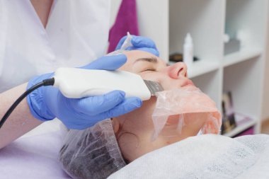 Kız güzellik salonunda bir ultrason cilt temizleme hizmeti ile sağlanır.