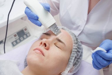 Kız güzellik salonunda bir ultrason cilt temizleme hizmeti ile sağlanır.