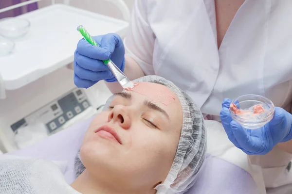 Maestro crea una máscara en la cara de una joven . — Foto de Stock