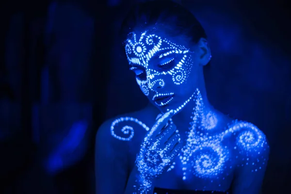 stock image Body art on the body and hand of a girl glowing in the ultraviolet light.