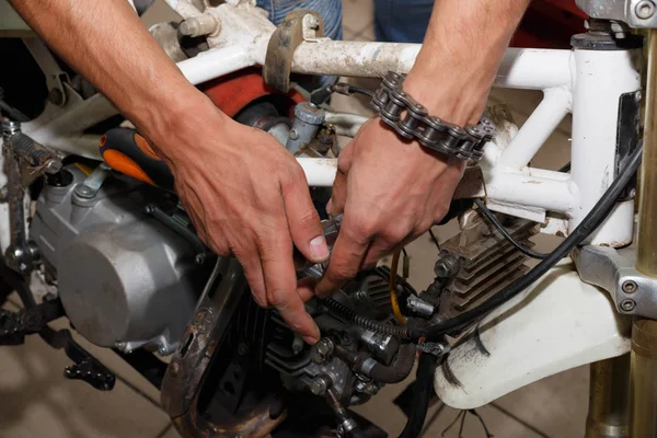 Майстер демонтує мотоцикл для роботи на електричній частині мотоцикла — стокове фото