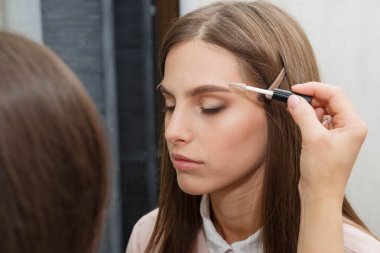 Makyaj sanatçısı modelin yüzünde eyeliner oluşturur.