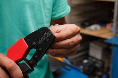 Sihirbaz motosiklet üzerinde hasarlı bir yerine yeni bir elektrik tel hazırlanıyor.