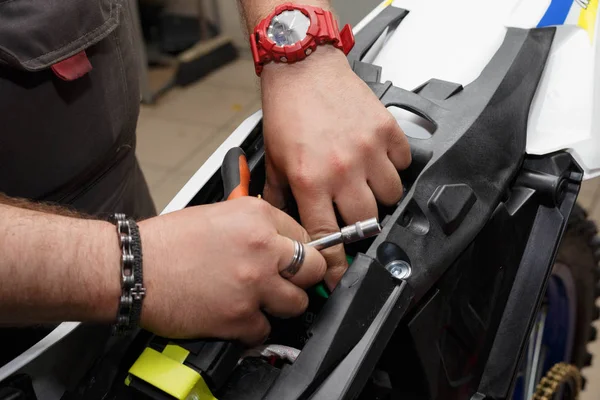 Мастер устанавливает новую батарею на мотоцикл после заправки и проверки . — стоковое фото