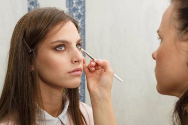 Makyaj yapma süreci. Makyaj sanatçısı bir bru ile çalışıyor