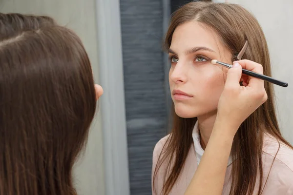 The process of creating makeup. Makeup artist working with a bru Stock Image