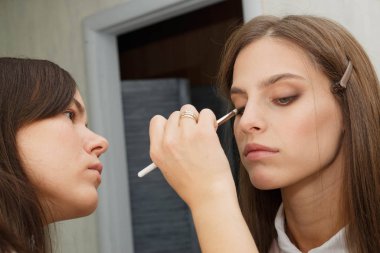 Makyaj yapma süreci. Makyaj sanatçısı bir bru ile çalışıyor