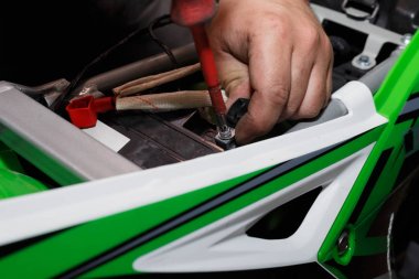 Sihirbaz motorlu yakıt ve kontrol sonra motosiklet yeni bir pil yükler.