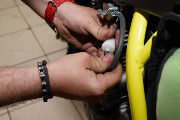 Мастер устанавливает или заменяет бензиновый фильтр на мотоцикле . — стоковое фото