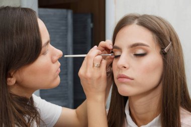 Makyaj yapma süreci. Makyaj sanatçısı bir bru ile çalışıyor