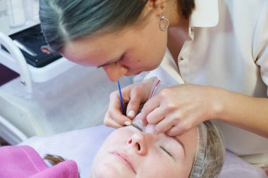 Makyöz, modelin yüzündeki kaşları vurguluyor.