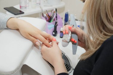 Kadın manikürcünün kuaförde çivi çakışının yakın çekimi. Tırnakları Fırçayla Temizleme.