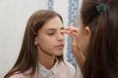 Makyöz, modelin yüzüne ton kremi dizer.