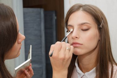 Makyaj yapma süreci. Makyaj sanatçısı bir bru ile çalışıyor