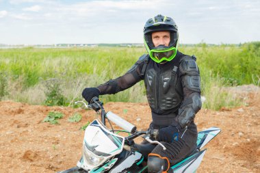 Motosiklet donanımlı bir adam dayanıklı bir motosikletin üzerinde oturur. Motokros binicisi iş başında. Motokros sporu. Aşırı off-road yarışı. Sert dayanıklı motosiklet.