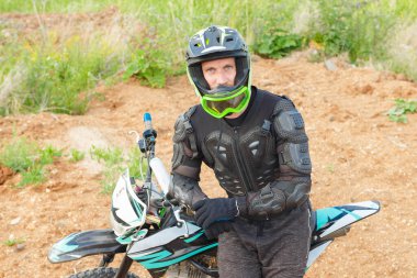Motosiklet donanımlı bir adam dayanıklı bir motosikletin üzerinde oturur. Motokros sporu. Sıra dışı off-road yarışı.