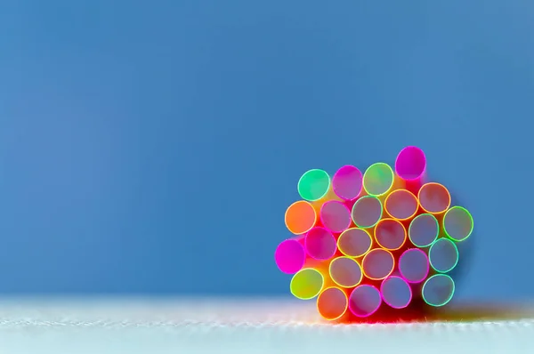 Group Of Plastic Straws For Drinks On The Blue Background. Colorful Tubes. Abstract