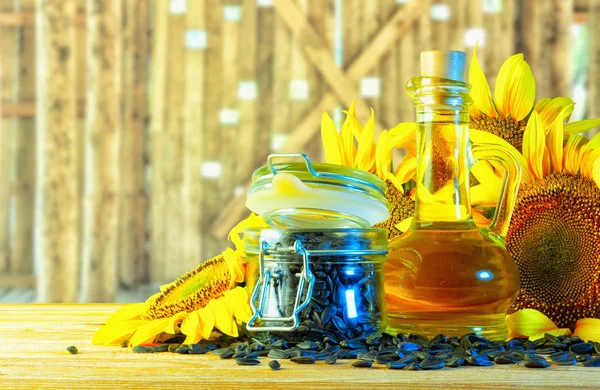 Sunflower oil in a bottle, surrounded by sunflower inflorescences