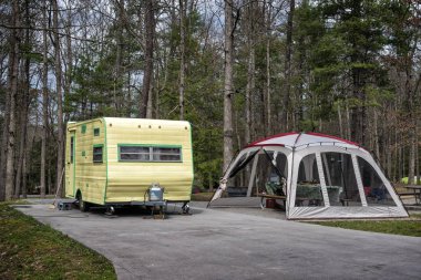 Yeşil trim ve bir çadır ile sarı bir camper ile Smoky Dağları kamp yatay bir kadeh. Yeşil ağaç arka plan.