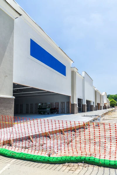 Dikey açılı bir kadeh yeni perakende inşaat alanında. Oranged örgü ile engellendi. İşte yeşil bir tüp yan boyunca koydu.