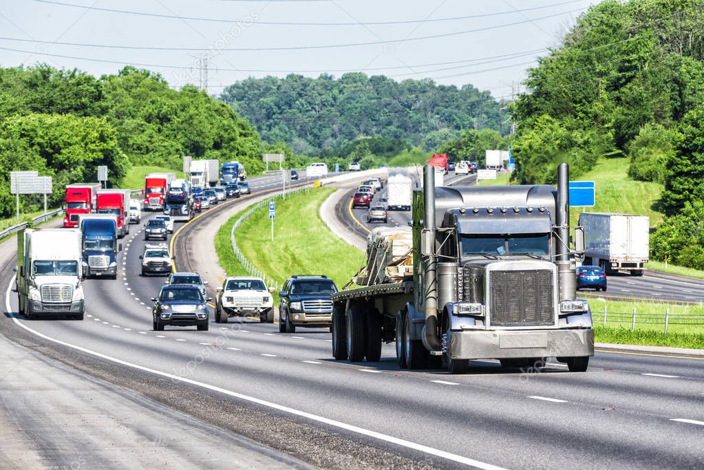 An interstate highway in eastern Tennessee bears a heavy load of traffic. Note: All logos and identifying marks have been removed from all vehicles.  Image was created on hot day, so heat waves from the asphalt create some distortion, especially on v