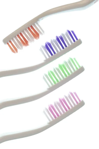 Cuatro coloridos cepillos de dientes aislados en blanco — Foto de Stock