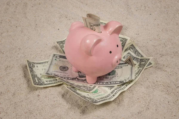 Ahorro de vacaciones en la playa con Piggy Bank y dinero en efectivo en arena — Foto de Stock