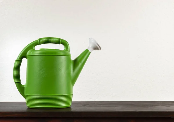 Green Watering Can Against White Textured Background With Copy S
