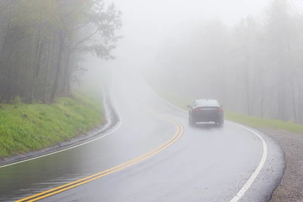 카피 스페이스가 있는 조밀한 연기가 자욱한 산안개속으로 자동차가 사라집니다. — 스톡 사진