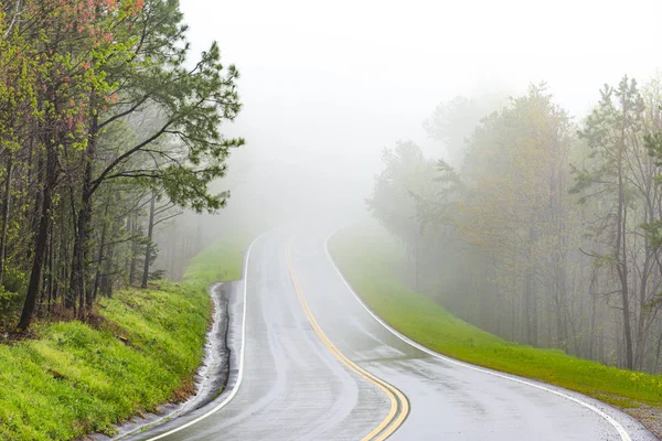 Curvando a estrada da montanha no nevoeiro com espaço de cópia — Fotografia de Stock
