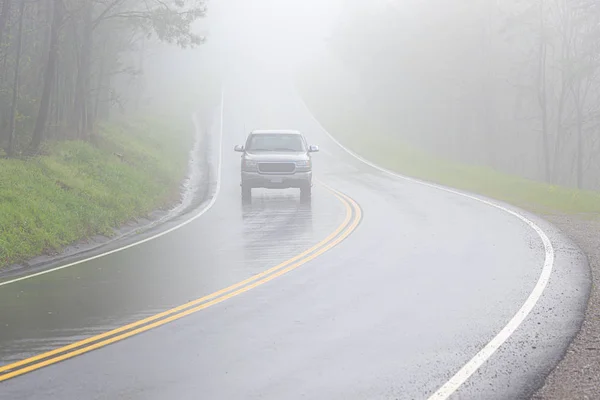 Camion di rimorchio solitario guida attraverso nebbia densa con spazio di copia — Foto Stock