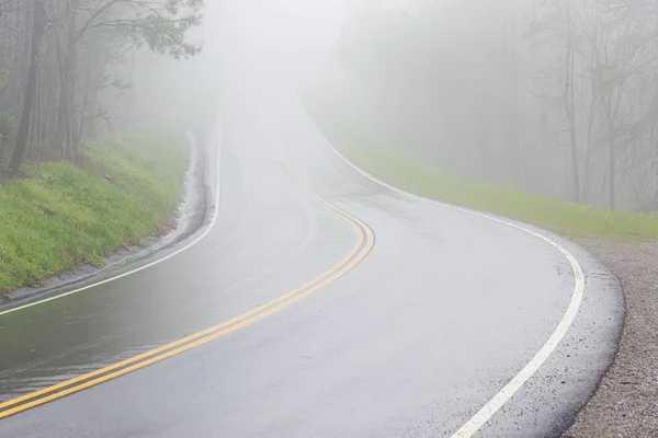 La nebbia copre la strada fumosa curva della montagna con lo spazio della copia — Foto Stock