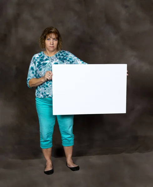 Rozzlobená nebo znepokojená žena středního věku držící prázdný znak — Stock fotografie
