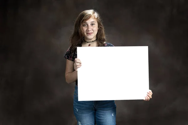 Divertito pre-giovanissima ragazza con lentiggini holding vuoto segno — Foto Stock
