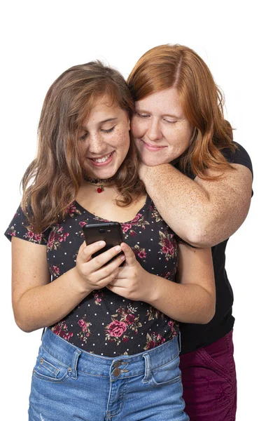 Madre e hija sonriendo mientras miran el teléfono celular —  Fotos de Stock