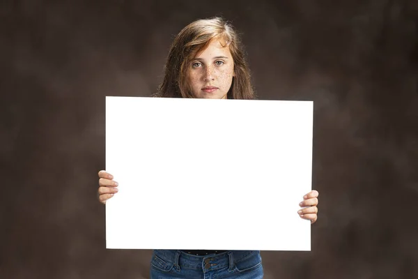 Προ-έφηβος κορίτσι με όμορφα μάτια κρατώντας κενό λευκό σημάδι — Φωτογραφία Αρχείου