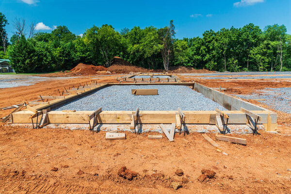 Horizontal shot of a wooden frame and crushed rock ready for a concrete slab to be poured.