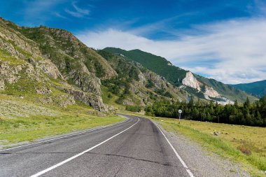 Rota Altay Dağları'nda, yaz günü Rusya Federasyonu Altay Cumhuriyeti içinde. Asfalt yol, dağlar, yaz, yüksek dağlar, yol işaret mesafe bırakarak