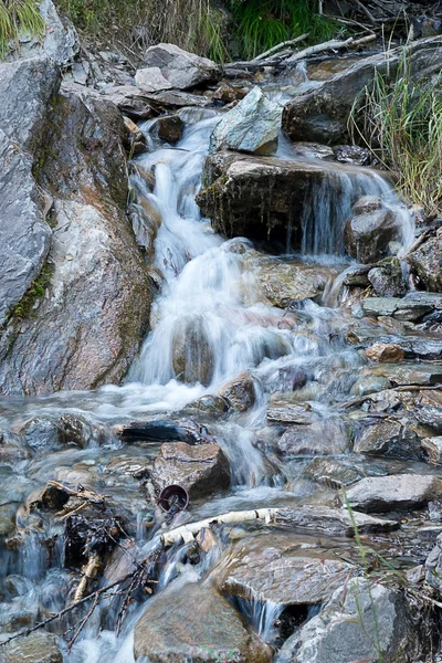 mountain waterfall Shirlak close-up, Altai Republic, Russia. a small waterfall running down the rocks, cloudy weather