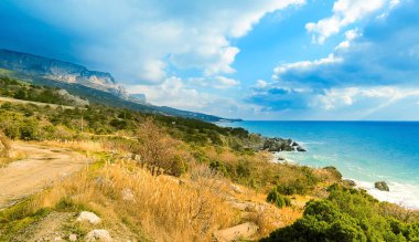 Sarych Burnu, Kırım dağlarına bakan deniz manzarası, güneşli kış, Ukrayna. Karadeniz kıyısında bir dizi farklı tepe ve dağlar, güneşli gün ışığı.