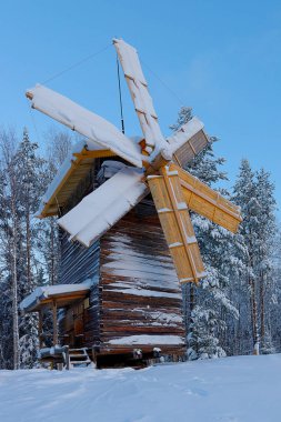 Karla, turizm kompleksi Malye Karely, Arkhangelsk region, kaplı ahşap değirmen Rusya üzerinde bıçak değirmen ahşap inşaat kar, dikey fotoğraf yatıyor.