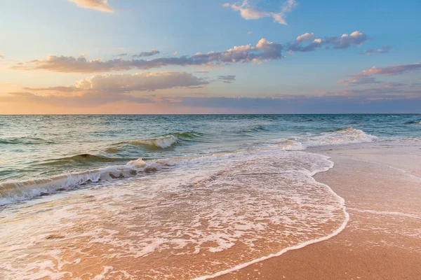 Witte schuimgolven op het zand bij zonsondergang in de zee — Stockfoto