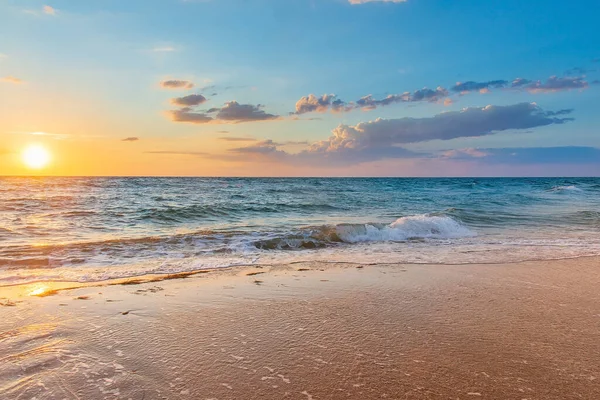 Onde di schiuma bianca sulla sabbia al tramonto in mare — Foto Stock