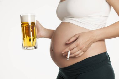Bir kupa bira ve sigara onun elinde tutan genç hamile kadın
