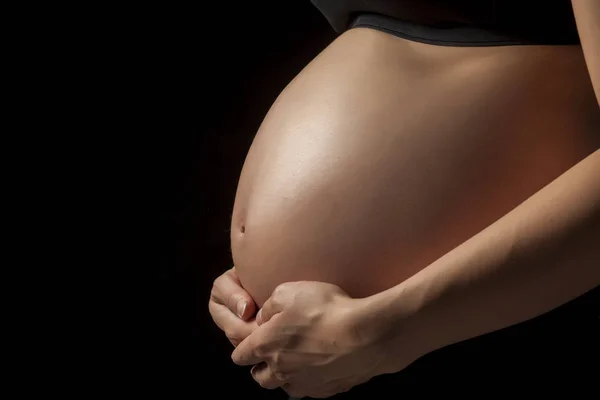 Brzuch Ciąży Kobiety Rąk Ciemnym Tle — Zdjęcie stockowe