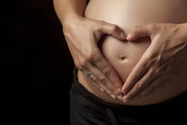 Pancia Una Donna Incinta Con Mani Forma Cuore Uno Sfondo — Foto Stock